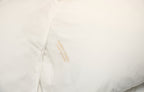 Close-up of a white pillow case with Yahweh Homes Embroidery.